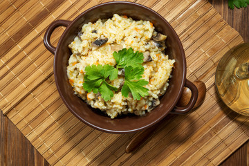 Rice with mushrooms and carrot or pilaf with parsley on wooden r