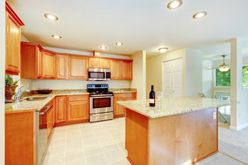 Bright kitchen room with light brown cabinets and steel appliances