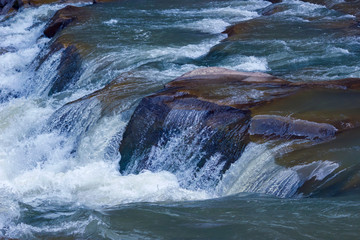 River waterfall on rock stones of mountain