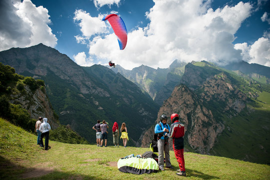 people prepare for paragliding in the mountains
