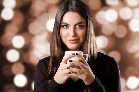 Portrait of pretty woman with cup of coffee on blurred background