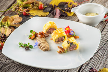 exclusive puff pastry appetizer with meat pie decorated with mushrooms and herbs on white plate with autumn leaves and sauce, product photography for restaurant