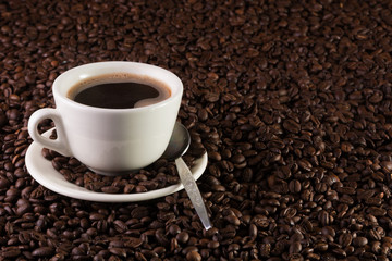 Cup of coffee on a background of coffee beans