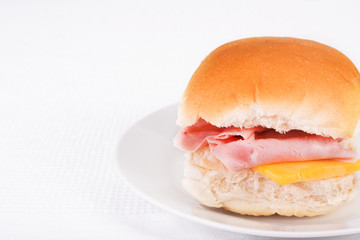 Ham and cheese bread roll or bap on a white plate
