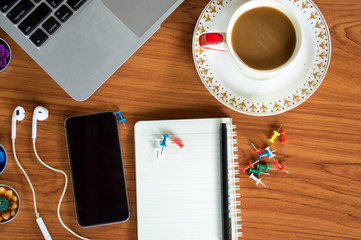 Office table with notepad, laptop and coffee cup.View from above with copy space.

