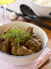 Chinese Styled Pork Rendang w steamed white rice and wine in background. Not sharpened file
