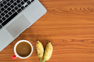 Office table with notepad, laptop and coffee cup.View from above with copy space.


