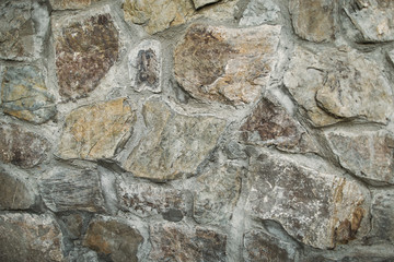 Stone wall texture of gray and brown colors. Horizontal color photo.