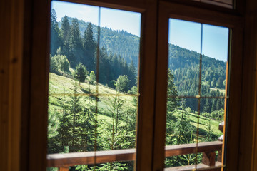 Beautiful view from country wooden house. Nature landscape seen through window.