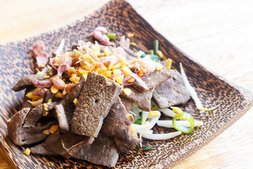 Closeup Cooked Liver in wood plate on wood table background, selective focus