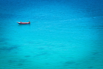 The boat in the azure ocean