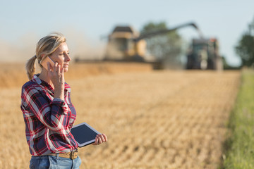 Female farmer using digital tablet in the wheat field
