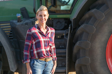 Female farmer and her tractor - 117598420