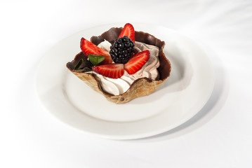 Vanilla and strawberry cream with fresh strawberries and blackberries in a waffle cone.
