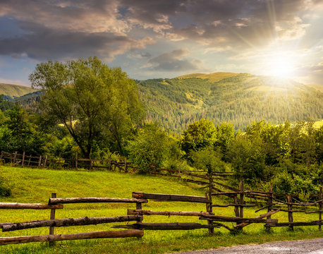 wooden fence on hillside at sunset
