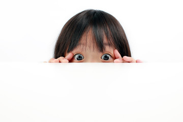 A cute Asian girl peaking over a table's edge