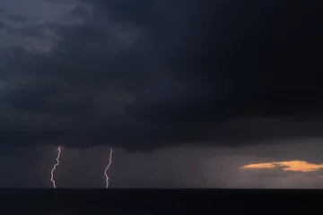 Photo sur Plexiglas Mer / coucher de soleil Lightning storm over the sea during sunset