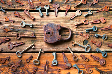 Fototapeta na wymiar Old rusty padlock and keys on wooden background