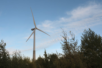 Windmill on rural field in the sunset. Wind turbines farm. Toning photo.