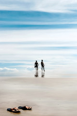 A walk through the heavens . Silhouettes of people on the beach