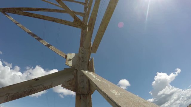Fragment electrical pylon against blue cloudy sky, time lapse 4K