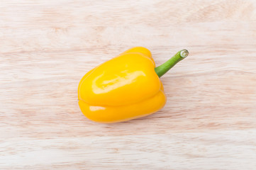 yellow ripe peppers lies on wooden cutting board