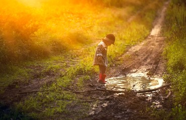 Boy playing in puddle in forest - 117613451