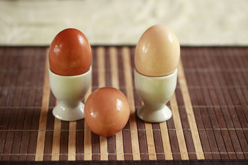 trzy jajka w różnych odcieniach na podkładce - obrazy, fototapety, plakaty
