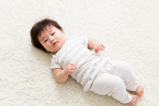 asian baby lying on the floor