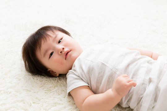 asian baby lying on the floor