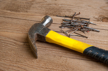 old hammer and nails on a wood background
