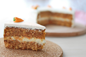 Tasty slice of carrot cake on cork plate