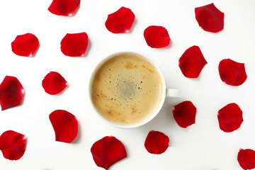 Red rose petals with cup of coffee on white background