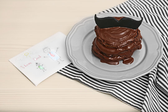 Chocolate pancakes with mustache and paint on table. Happy fathers day concept