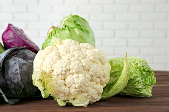 Different kinds of fresh cabbage on brick wall background