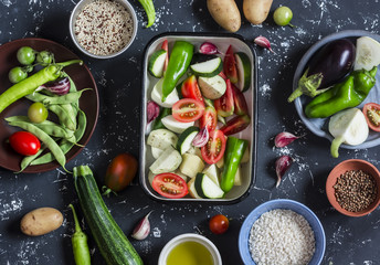 Cooking lunch - fresh raw vegetables, quinoa, rice, spices on a dark background. Vegetarian, diet food