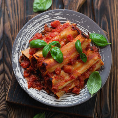 Above view of baked cannelloni with minced meat and tomato sauce