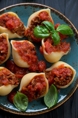 Close-up of conchiglioni stuffed with mincemeat and tomato sauce