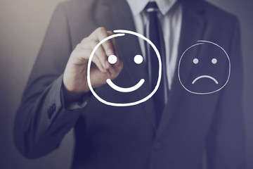 Customer choosing to write satisfied face over unhappy face