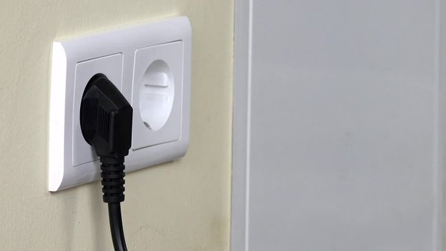Man hand Put Plug Into Electricity Socket