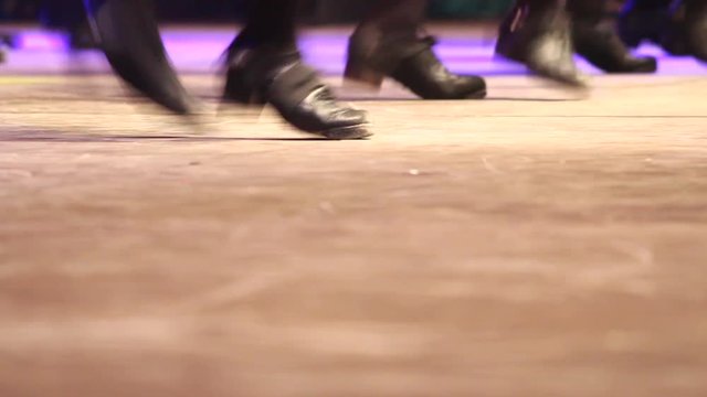 Close up three group of women doing Irish dance with traditional step shoes. Trio of female dancing feet on stage. Music, tradition and culture of Ireland. Celtic show on wooden floor