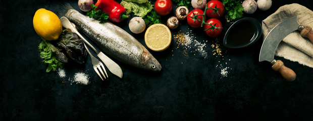 Top view of fish with vegetables and spices. Cooking or healthy concept, with copy space, toned