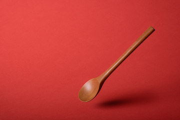 Wooden spoon on red background