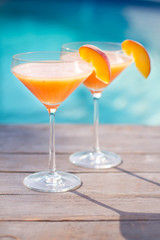 Bellini cocktail with peach isolated near pool