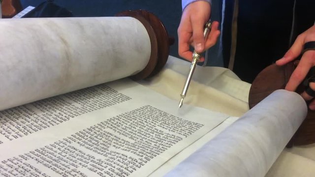 AUCKLAND - AUG 04 2016:Jewish rabbi read Torah.Traditionally the words of the Torah are written on a scroll by a sofer on parchment in Hebrew. Reading the Torah is one of the bases for Jewish life.