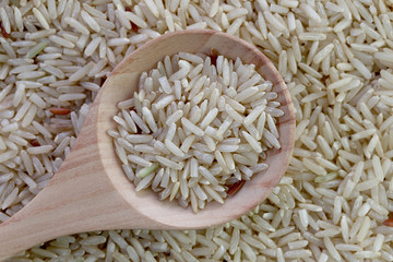 Organic brown rice in wooden spoon for nature food background.