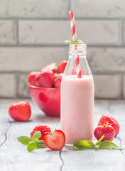 Strawberry smoothie or milkshake in a glass bottle 