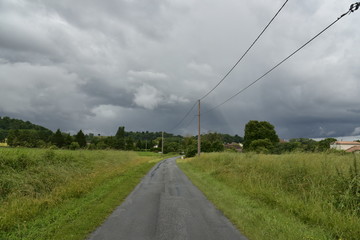Route de campagne secondaire sous un nuage sombre d'un puissant front froid orageux au P&eacute;rigord Vert