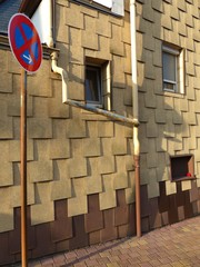 Restaurierte Fassade in Beige und Naturfarben mit geometrischem Muster eines alten Wohnhaus mit...