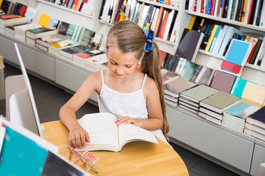 girl reading a book in the school library